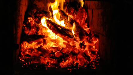 Christmas fire in the fireplace with firewood for comfort in the house