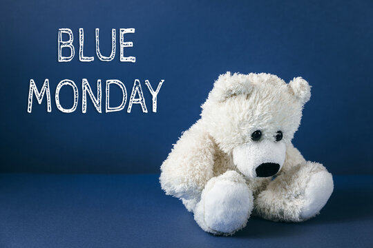A sad teddy bear on a blue background with "Blue Monday" lettering. The saddest day of the year. Blue monday creative concept.