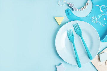 Blue baby plate with cutlery on table