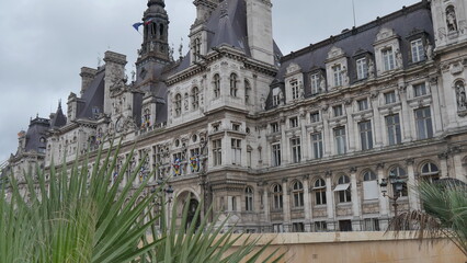 Fototapeta na wymiar La mairie de Paris et son coin jardinier, ciel gris et nuageux, batiment historique et ancien, style gothique, ancien et historique, centre administration