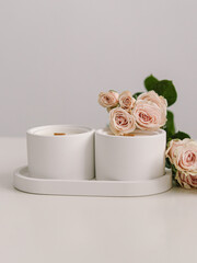 Two coconut wax candles in concrete cups. Scented candles for interior. Candles with the aroma of roses. Space for text