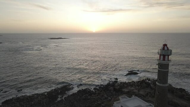 Amanecer en el mar y proyecci&oacute;n de faro 