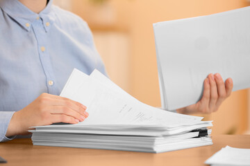 Woman working with documents at table in office, closeup