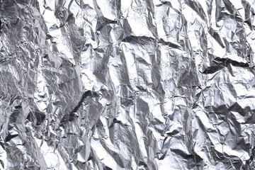 Crumpled silver foil as background, closeup view