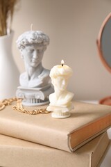 Beautiful David bust candles and books on table