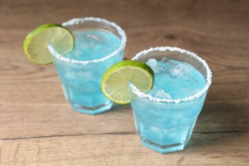 Refreshing light blue cocktail on wooden table