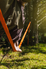 Barefoot of an unrecognizable person walking on a rope, slackline.