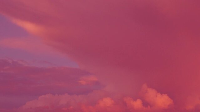 Tinted pink sky. Beautiful sky background with clouds. A time lapse of a cloudy sky