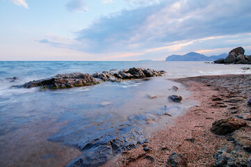 Landscape with sea shore, waves and stones on the rocks beach.