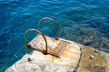 rusty boarding aid to the Mediterranean sea on a concrete platform on the island of Capri, Italy
