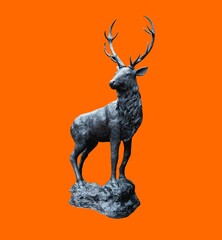 Beautiful and traditional british Deer Stag bronze, or alloy statue or sculpture cut out against a orange background