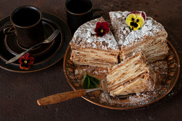 Cake "Napoleon" from puff pastry, decorated with blueberries and flowers.