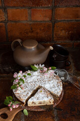 Shortcrust pastry pie with raisins. Still life against a terracotta brick wall.