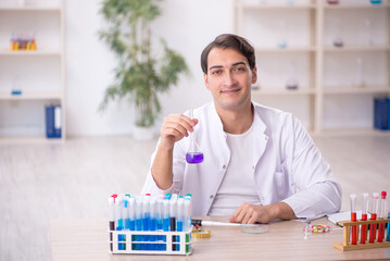 Young male chemist working at the lab