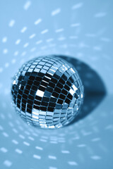 Festive background. Disco ball, mirror ball. Blue toning, light radial reflections, close-up.