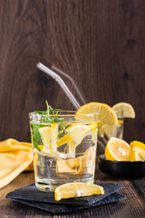 Water with lemon and rosemary in glasses on the table. Detox drink. Vertical view