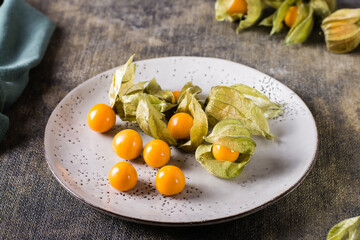 Ripe fruit cape gooseberry on a plate. Exotic vitamin nutrition.