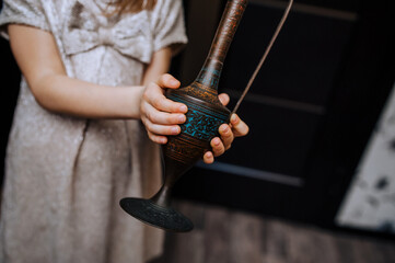 A girl, a child, who found an old lamp, a jug with a pattern rubs her hand, waiting for a genie....