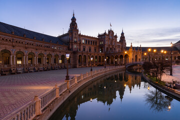 Fototapeta na wymiar The beautiful decorated Plaza de España (English: Spanish Square) during an colourful sunrise is a touristic spot in a park in the centre of Seville, Spain, built in 1928 for the 1929 world exposition