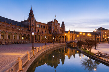 Fototapeta na wymiar The beautiful decorated Plaza de España (English: Spanish Square) during an colourful sunrise is a touristic spot in a park in the centre of Seville, Spain, built in 1928 for the 1929 world exposition