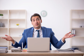 Naklejka premium Young male employee working in the office