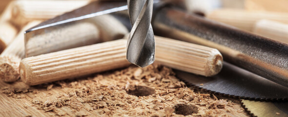 drill bit makes hole in wooden oak board for wooden dowel.