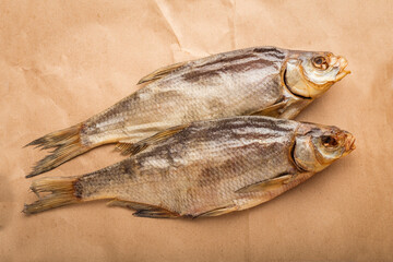 Two dried fish bream on a Kraft paper background. The concept of an appetizer for beer. top view