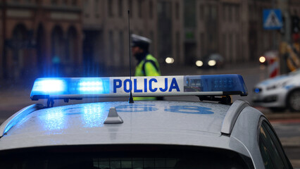 Incydent policji w mieście. - Sygnalizator błyskowy niebieski na dachu radiowozu policji polskiej...