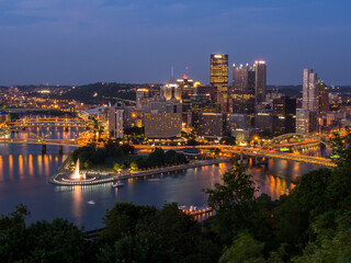 Fototapeta na wymiar Downtown Pittsburgh skyline at night with rivers, bridges, and the fountain at Point State Park.