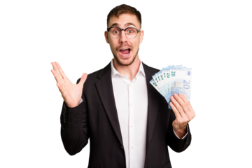 Young business caucasian man holding euro banknotes isolated cut out receiving a pleasant surprise, excited and raising hands.