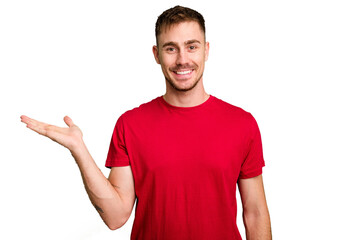 Young caucasian man cut out isolated showing a copy space on a palm and holding another hand on waist.