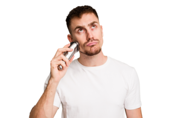 Young caucasian man using an electric shaver isolated cut out