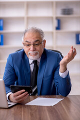 Old male employee working in the office