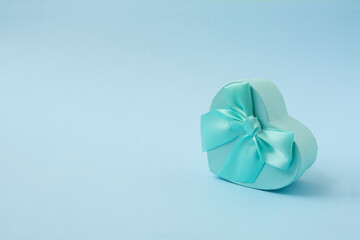 Light blue heart shape decorative gift box on pastel blue background. Valentine's day, holiday, Christmas, Thanksgiving Day, birthday front view.