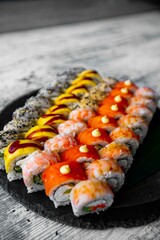 Assorted japanese sushi rolls on black background.