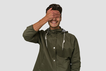 Young handsome caucasian man isolated on white background covers eyes with hands, smiles broadly waiting for a surprise.