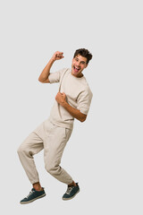 Fototapeta na wymiar Young caucasian man jumping isolated on white background