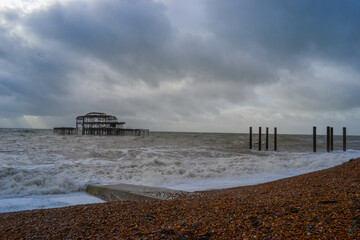 Burnt out Brighton Pier during a storm and sunset