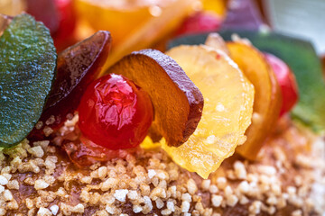 une cerise et des tranches de fruits confits sur un gâteau - 559599663
