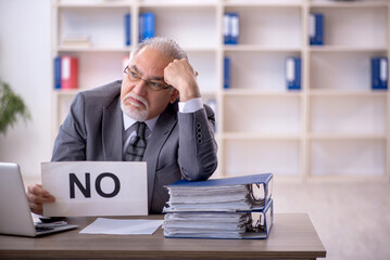 Old male employee working in the office