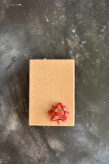  Gift box on a dark background, decorated with a textured bow.