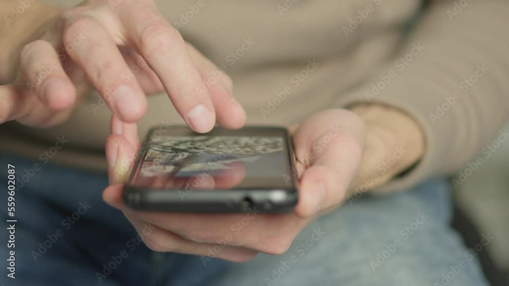 Poster A man's finger touches a monitor to scroll a page on a mobile phone. Viewing photos and documents in the smartphone library. A man in his hands uses a smartphone, turns pages.