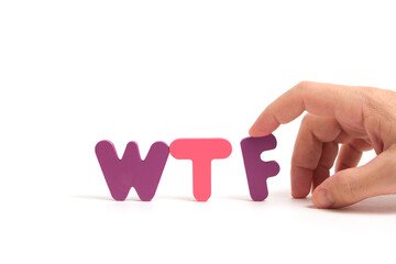 Man hand exposes abbreviation wtf in letters white background.
