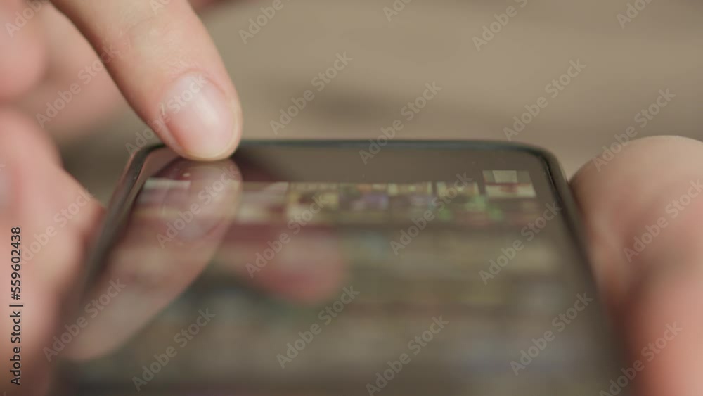 Poster A man's finger touches a monitor to scroll a page on a mobile phone. Viewing photos and documents in the smartphone library. A man in his hands uses a smartphone, turns pages.