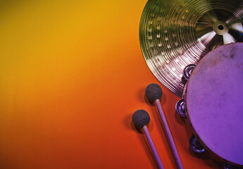 Colorful, music percussion template background, with a hand drum tambourine and drumsticks. An...