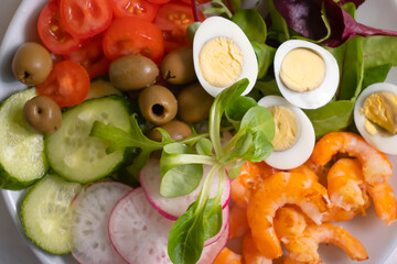 Salad with shrimps, tomatoes in a plate