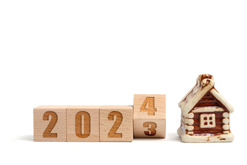 Wooden cubes with inscription 2023 turning into 2024 and house on white background.