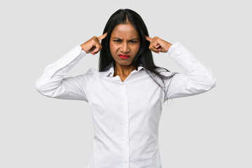 Young Indian woman cut out isolated on white background focused on a task, keeping forefingers pointing head.