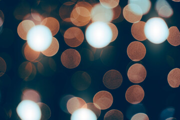 Abstract bokeh background burning light bulbs evening city and garlands.