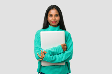 Fototapeta premium Young indian woman holding a laptop isolated on white background
